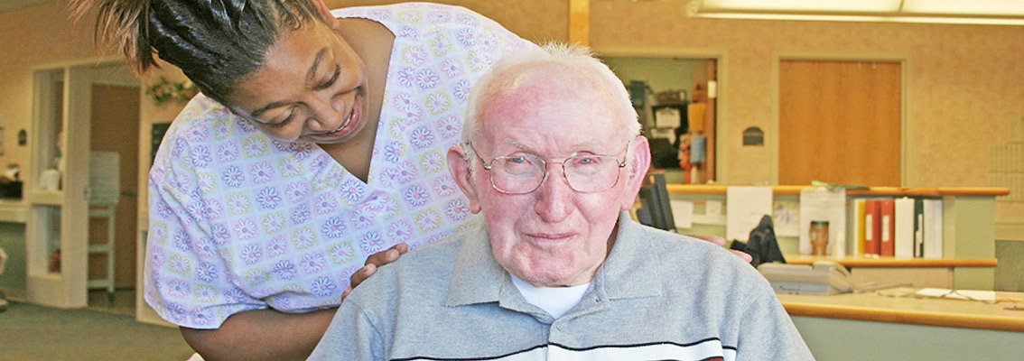 Elderly Man with aide in Nursing Home