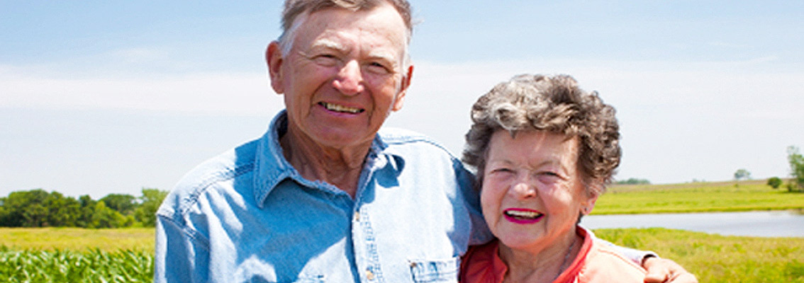 Senior Farmer and Wife standing in field